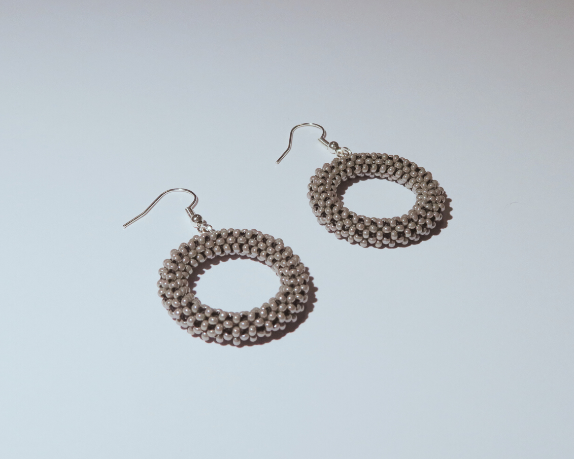 Pair of circular earrings on a light gray background