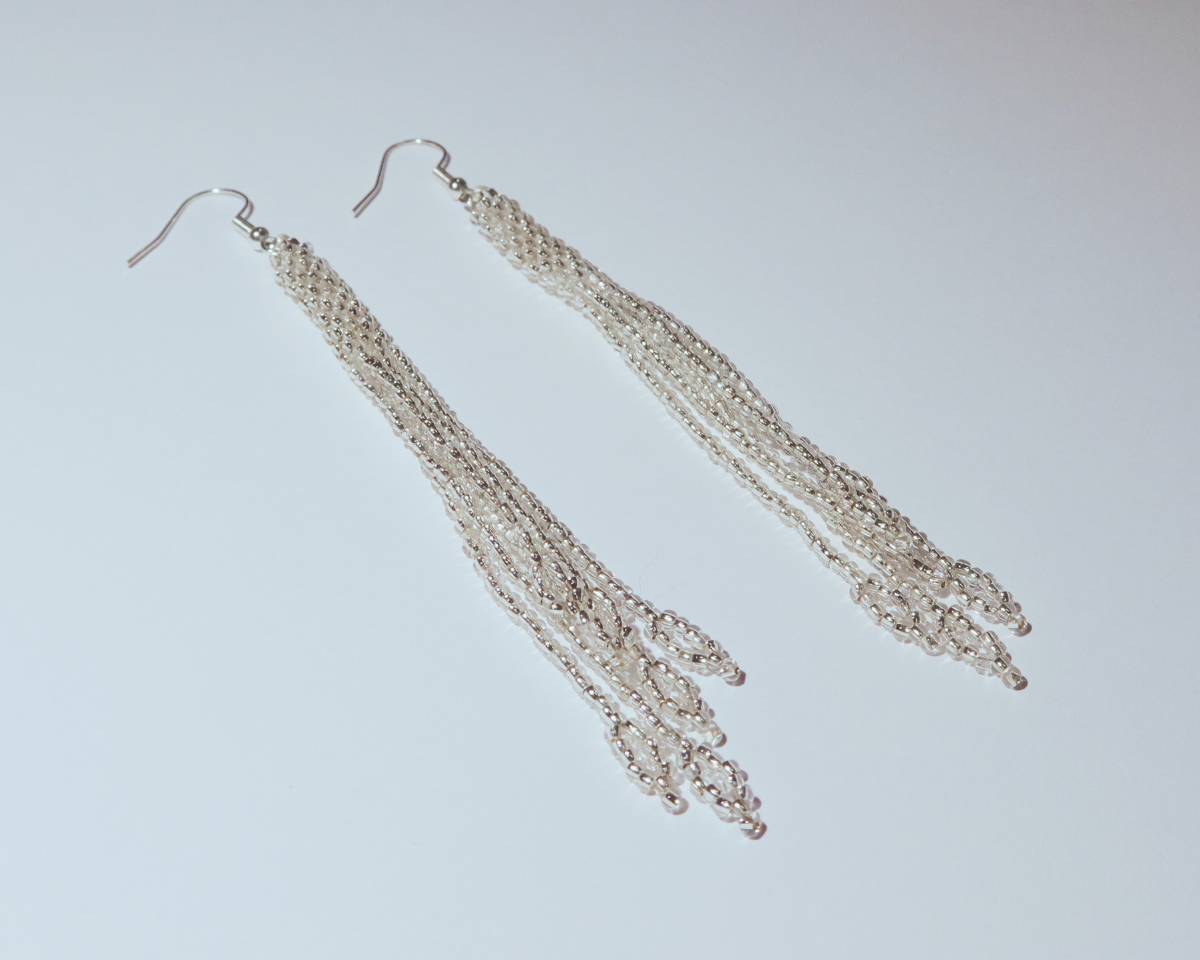 Pair of silver fringe earrings on a light gray background