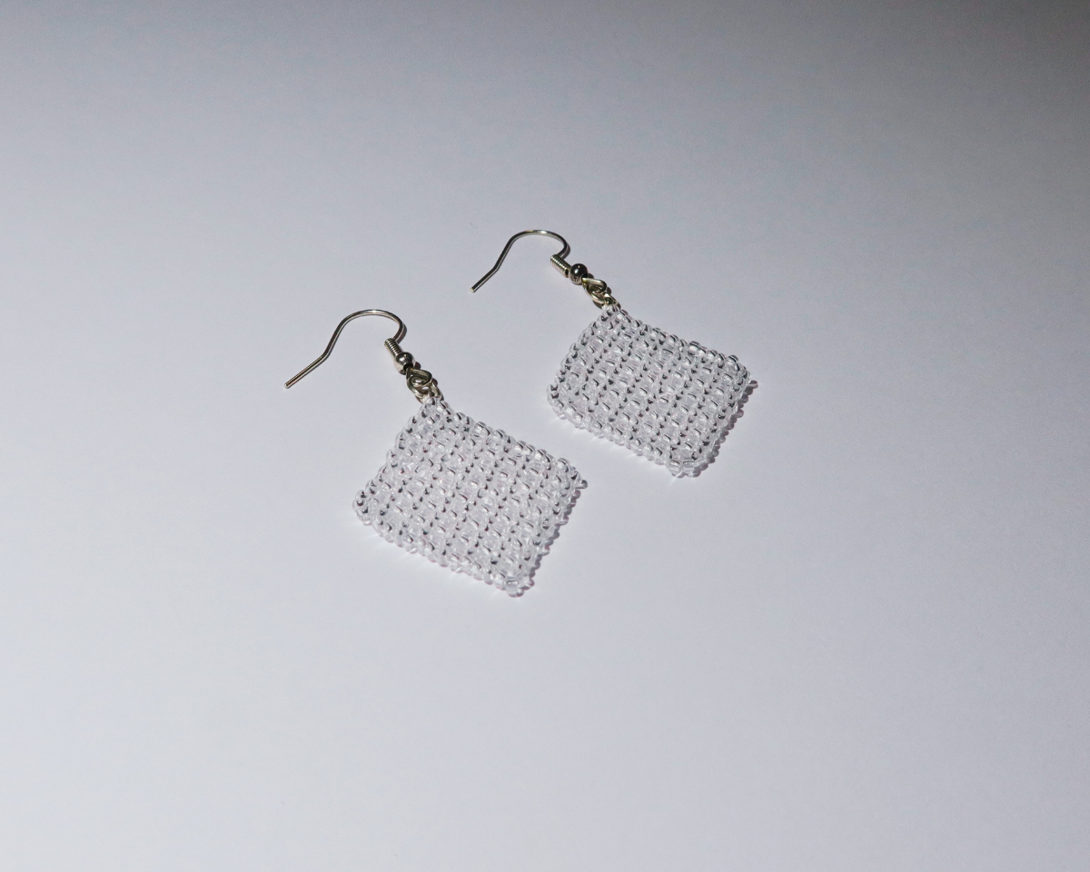 Pair of square mesh earrings on a light gray background