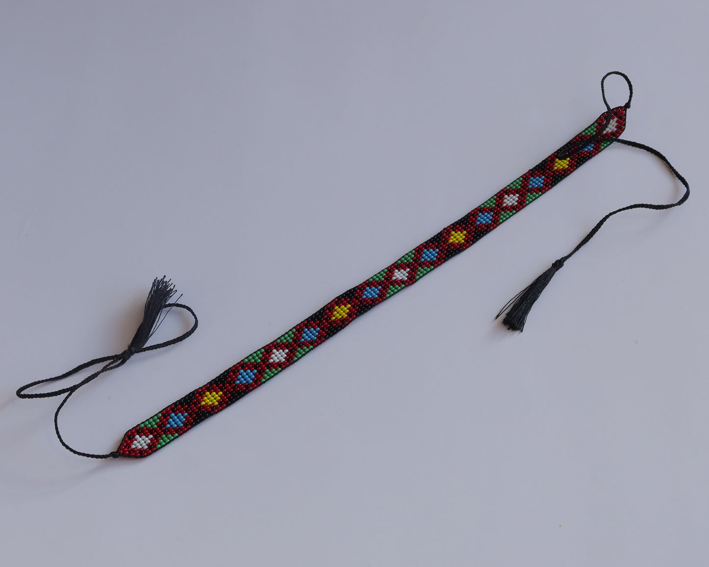 Colorful beaded lanyard with tassels on a white background