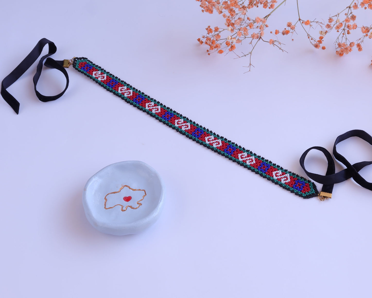 Comely UA Neresnytsia gerdan choker with red, blue, green, and white diamond beadwork and black velvet ties.