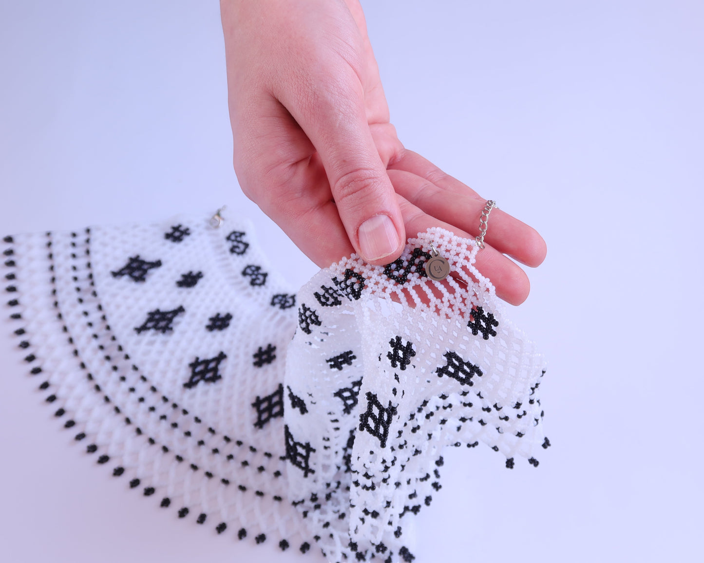 Comely UA "Primla" beaded necklace in black and white with diamond and cross symbols. Adjustable clasp.