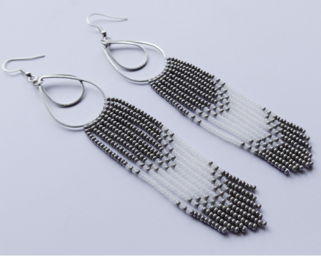 Pair of silver fringe earrings on a light gray background
