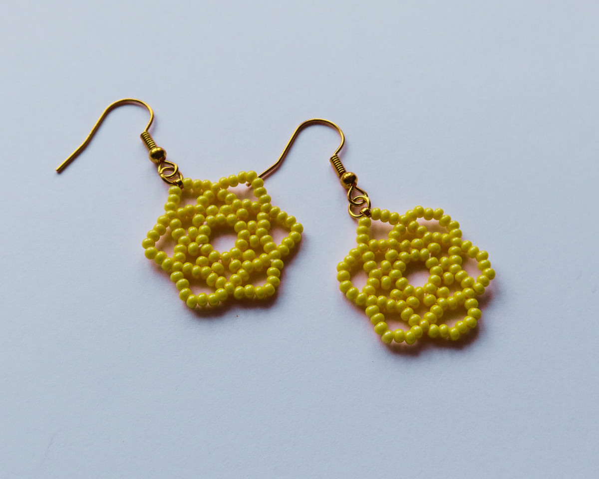 Yellow beaded earrings on a light blue background