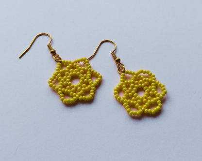 Yellow beaded earrings on a light blue background