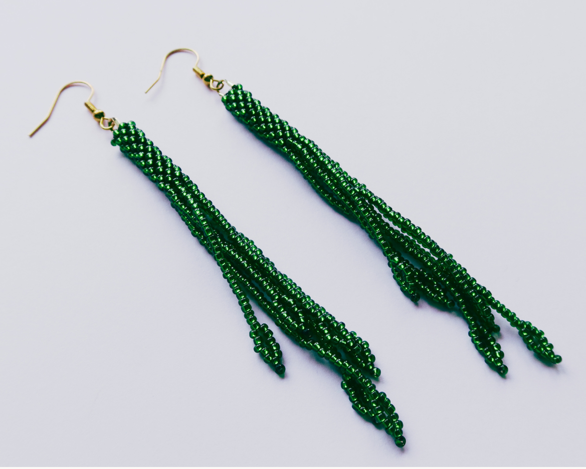 Green beaded earrings on a light gray background