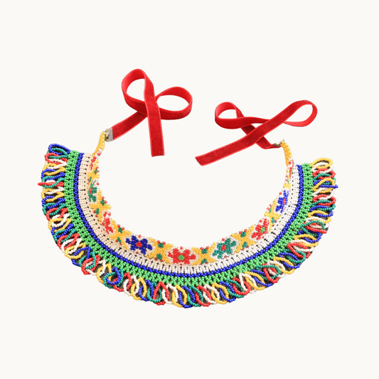 Colorful beaded necklace with floral patterns and red ribbons on a white background