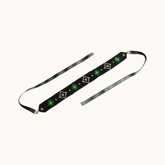 Black headband with green and white pattern on a white background