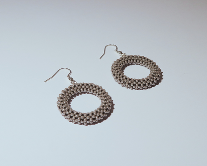 Pair of circular earrings on a light gray background