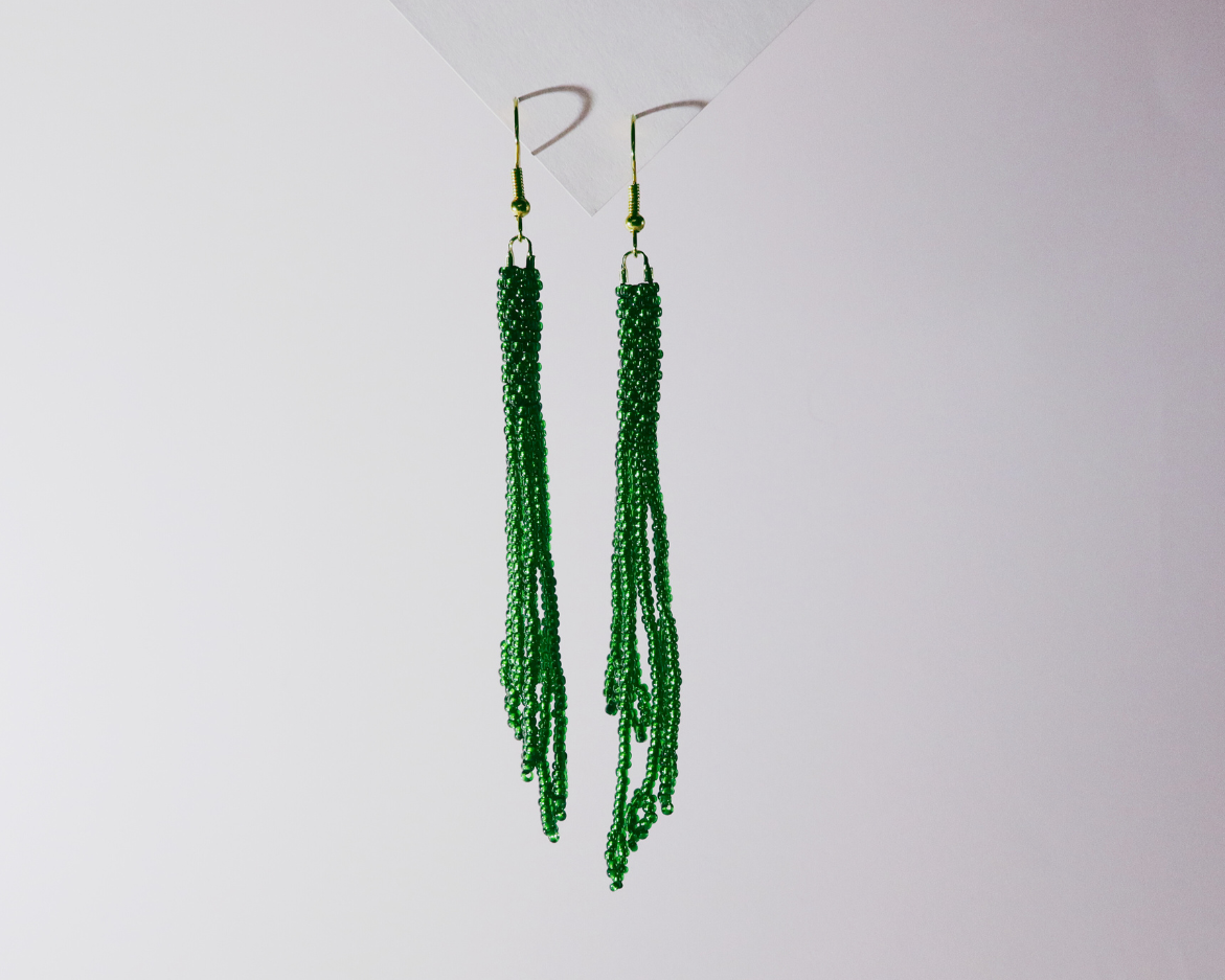 Green beaded earrings on a white background