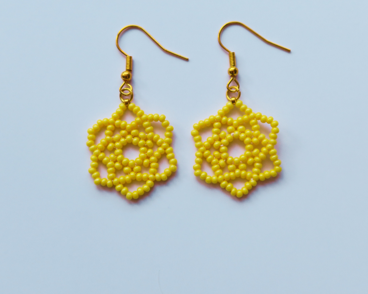 Yellow beaded earrings on a light blue background