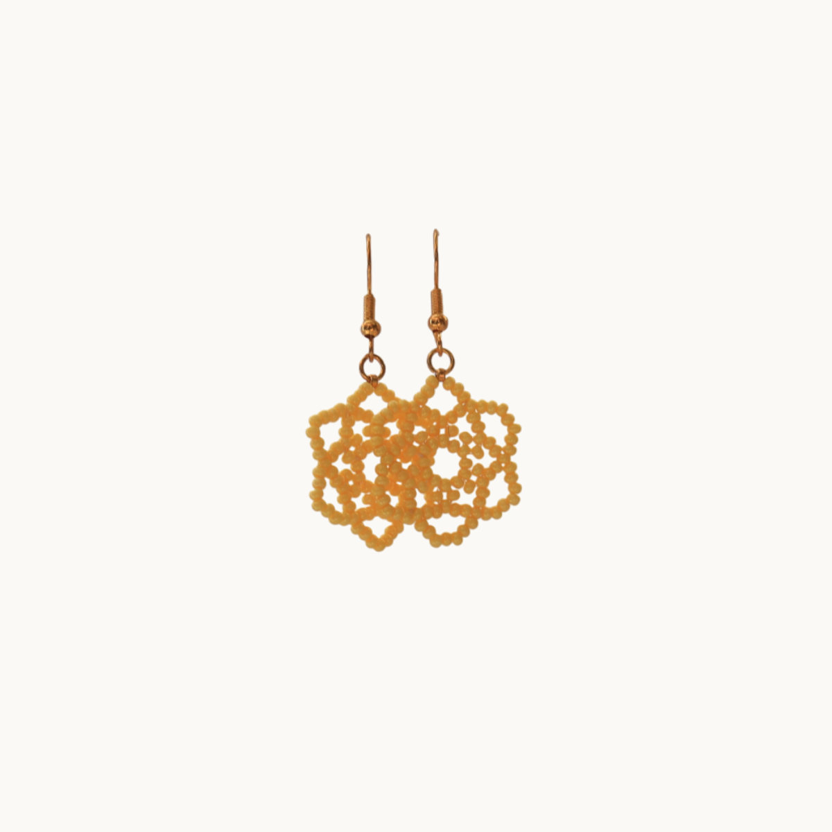 Gold lace-style earrings on a white background