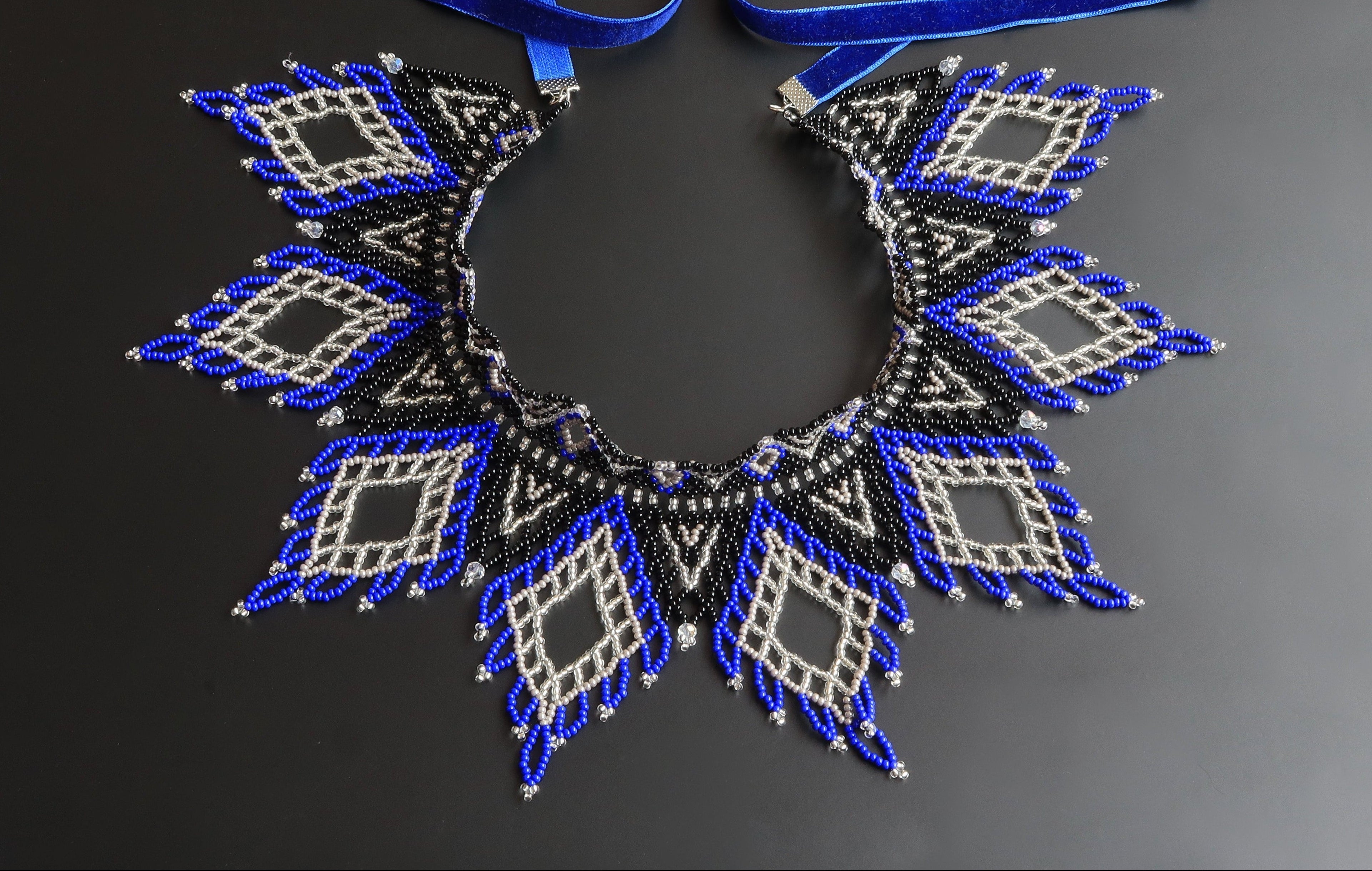 Decorative necklace with blue and silver pattern on a dark background