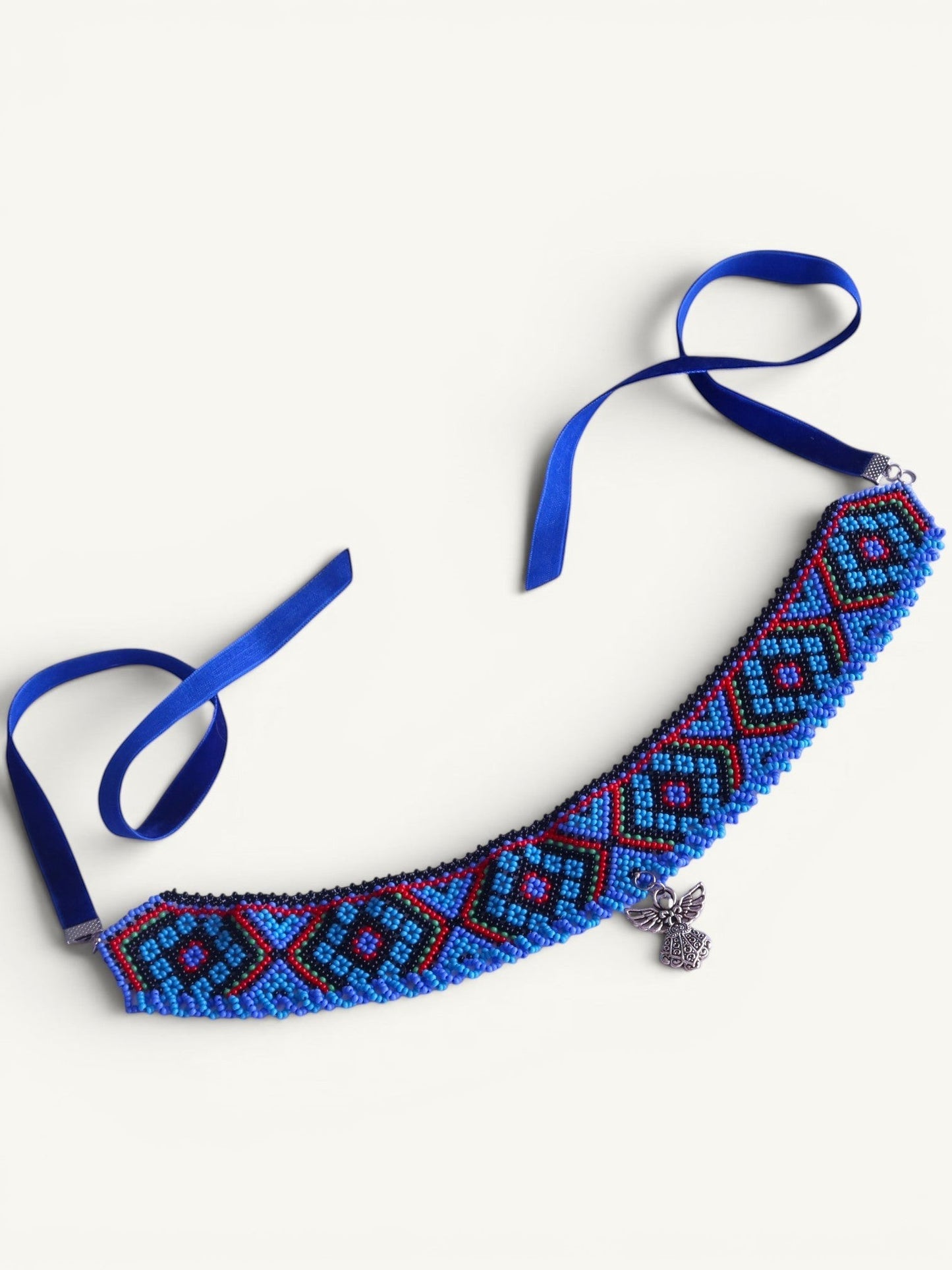 Comely UA blue, red, and black beaded choker with geometric pattern and angel charm. Velvet ties for adjustable fit.