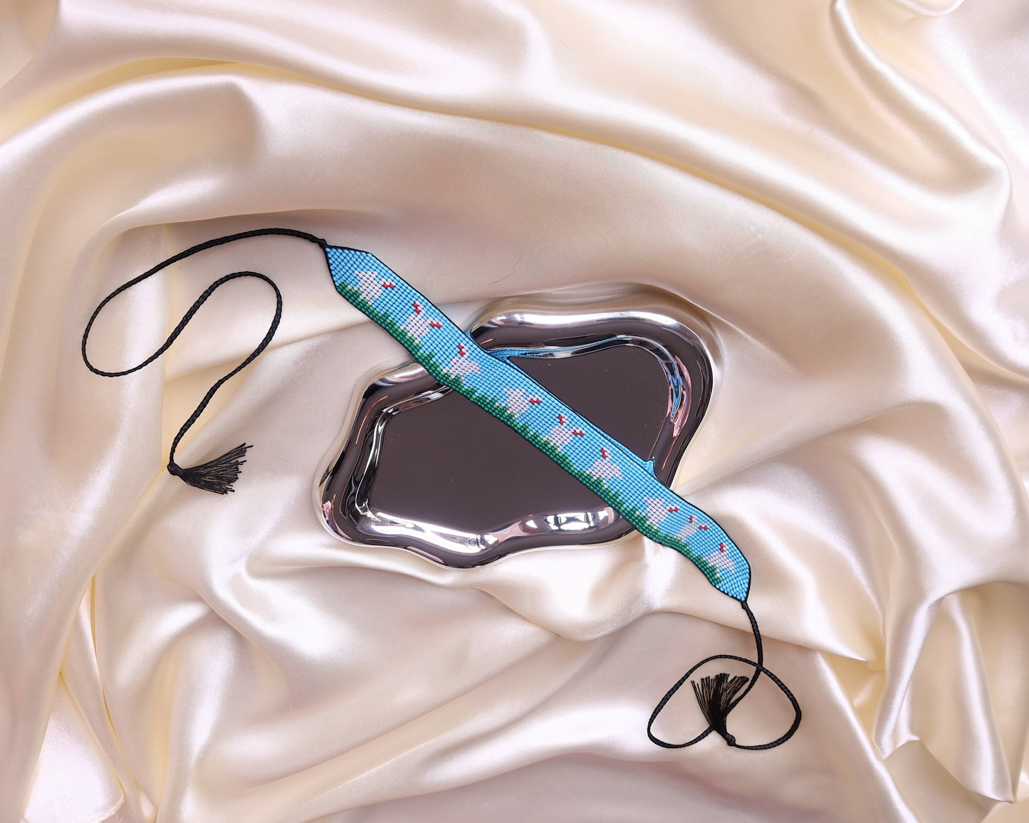 Comely UA beaded gerdan with blue, green, and white pattern of hares in a meadow. Adjustable ties with tassels.
