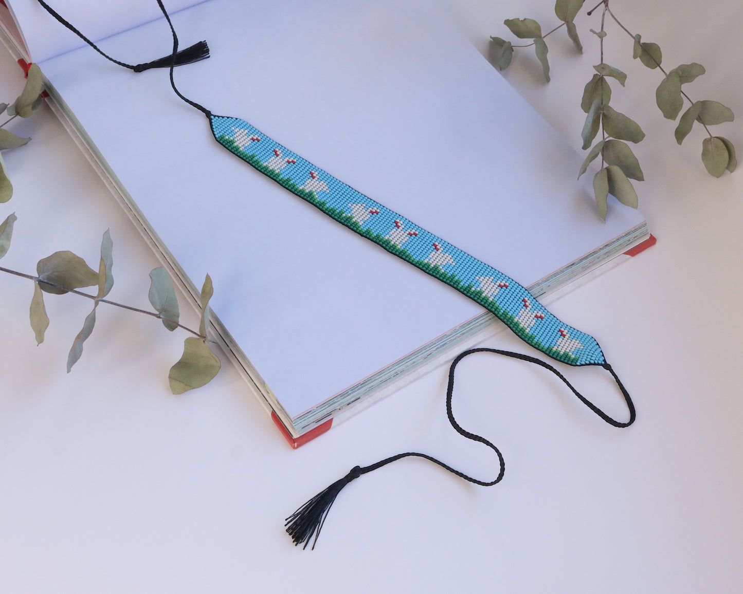 Comely UA beaded gerdan with white hares on blue sky and green grass pattern, adjustable ties with tassels.