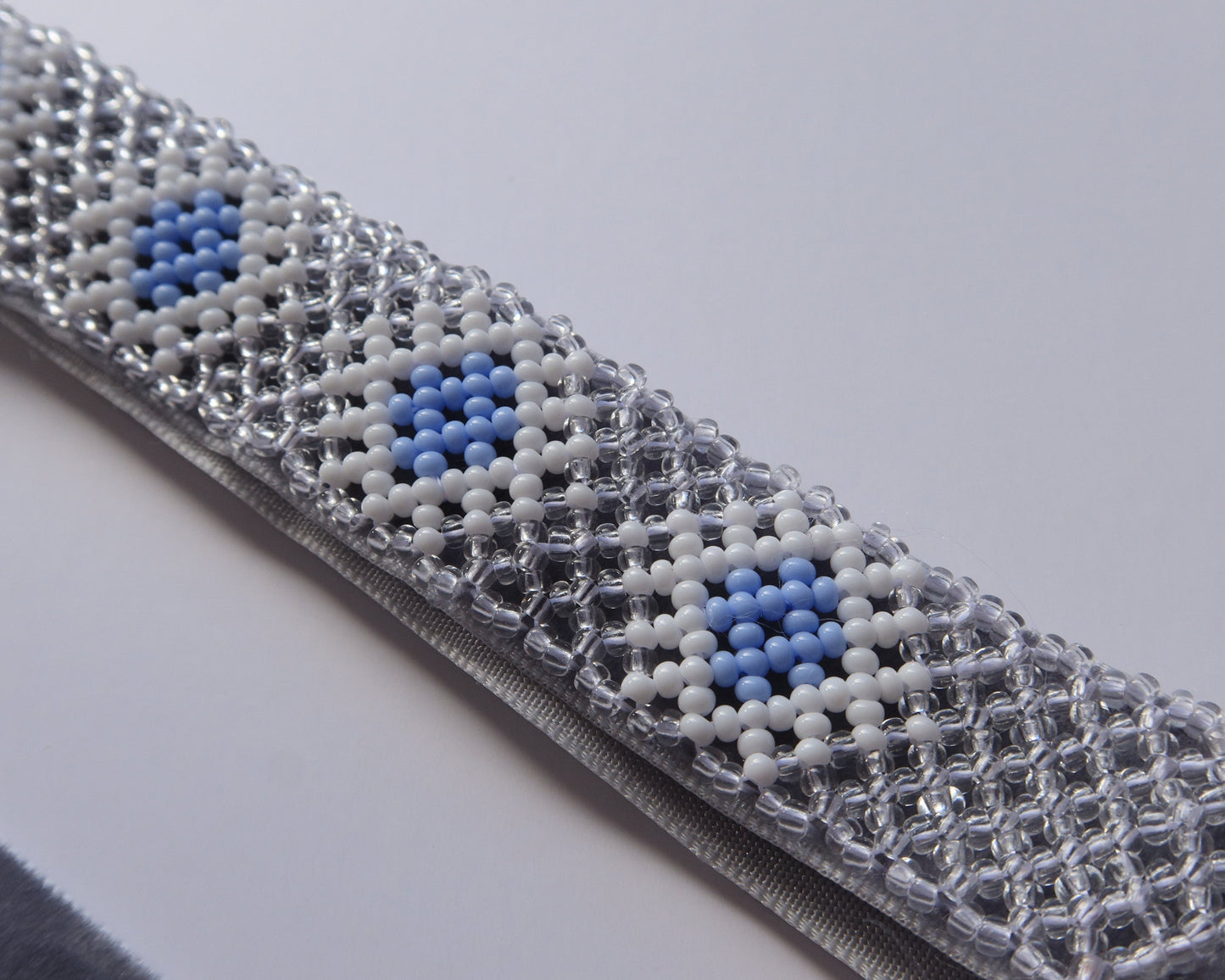 Comely UA beaded gerdan necklace with blue, white, and clear Czech seed beads in a rhombic pattern on a velvet ribbon.