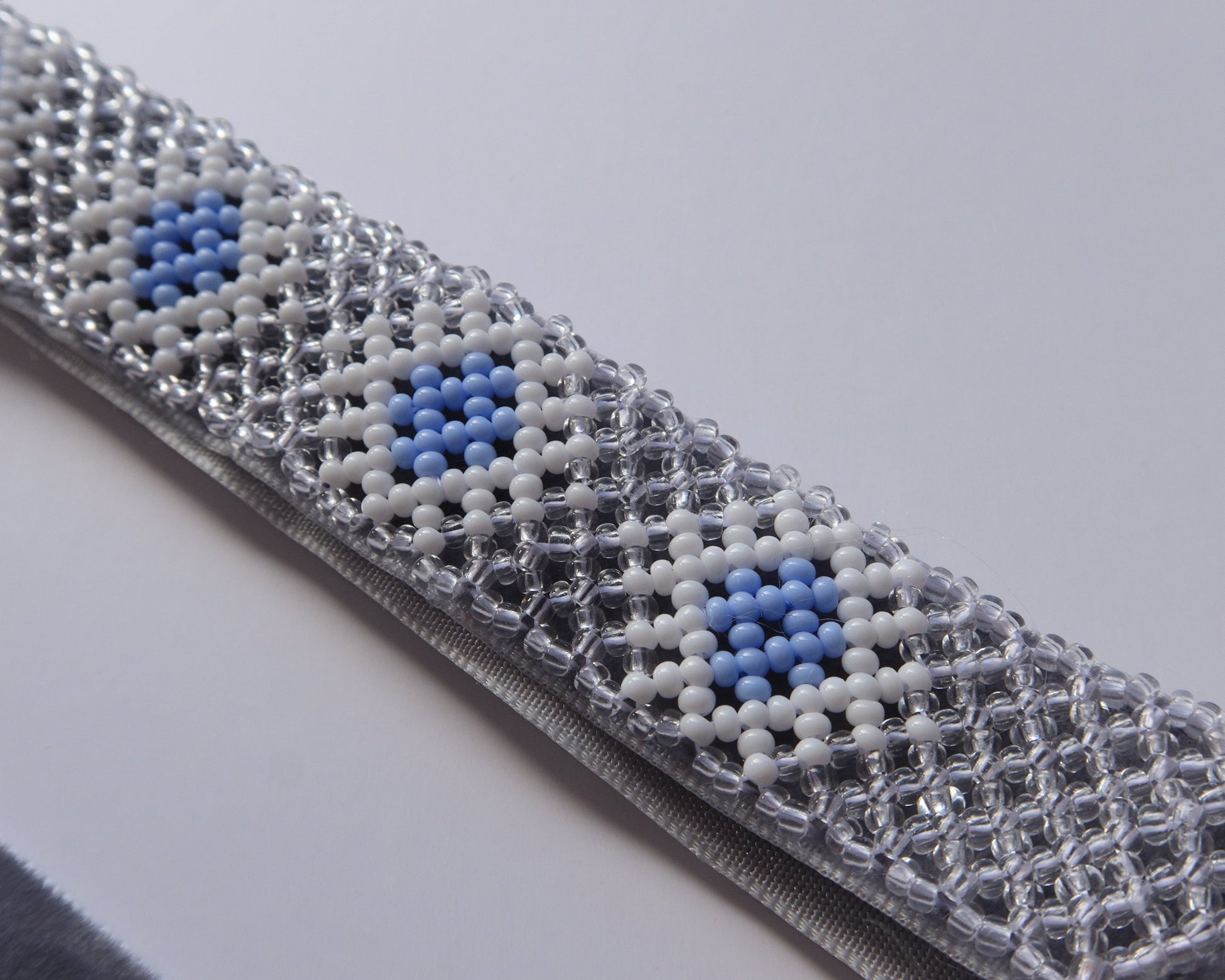 Comely UA beaded gerdan necklace with blue, white, and clear Czech seed beads in a rhombic pattern on a velvet ribbon.