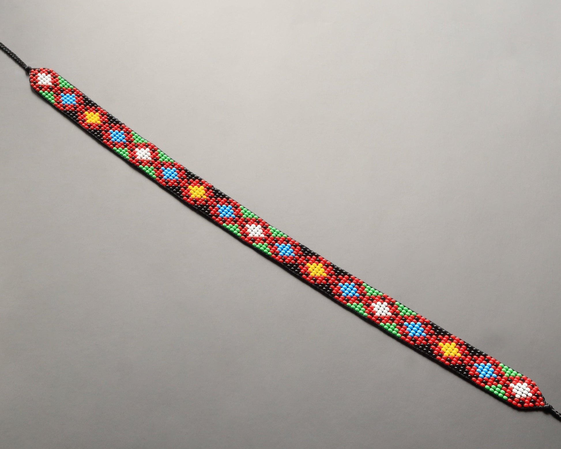 Comely UA beaded gerdan necklace with diamond pattern in red, yellow, blue, green, and white Czech seed beads on black nylon thread.