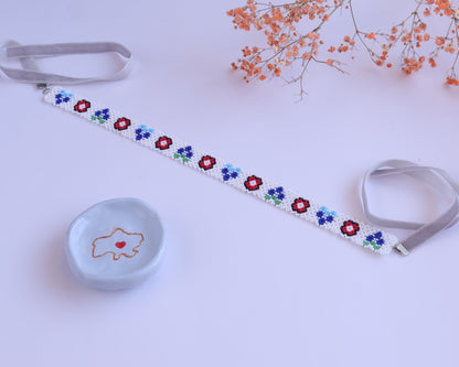 Comely UA white beaded gerdan necklace with red, blue, and green floral motifs and grey velvet ribbons.