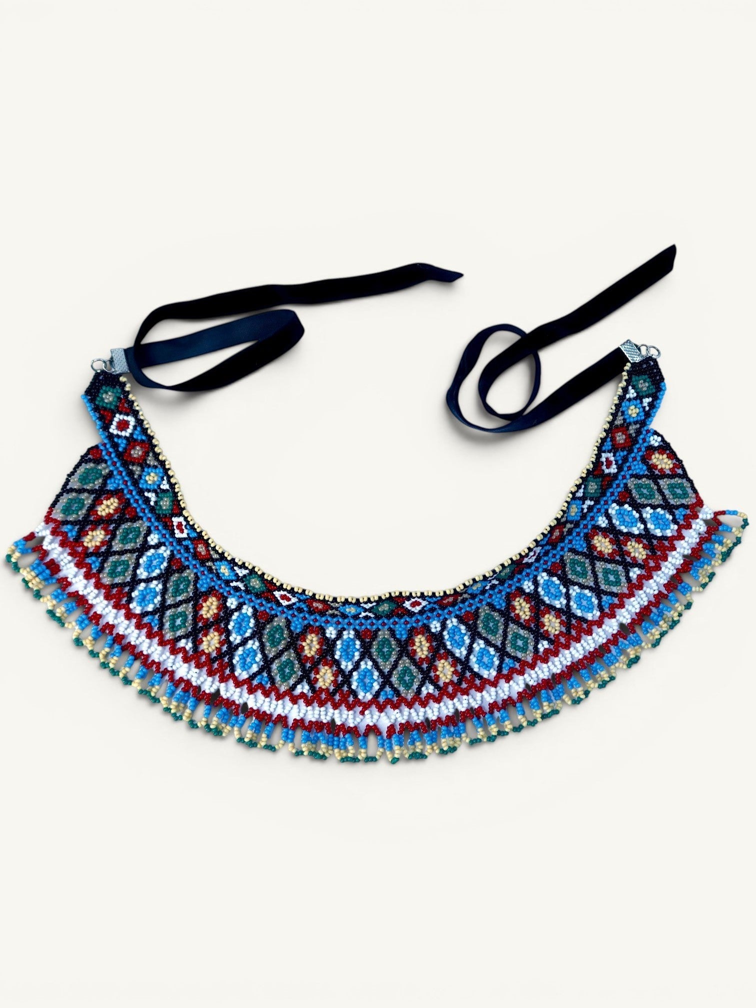 Comely UA two-part beaded necklace with geometric diamond pattern in red, blue, white, and green Czech seed beads, finished with velvet ribbons.