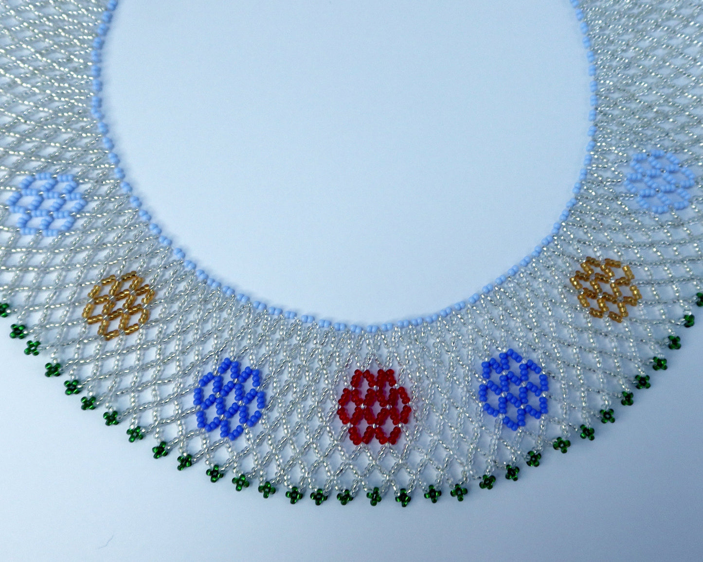 Comely UA beaded necklace with a mesh design, featuring red, blue, yellow, and green floral motifs. Replica of a historical Ukrainian silyanka.