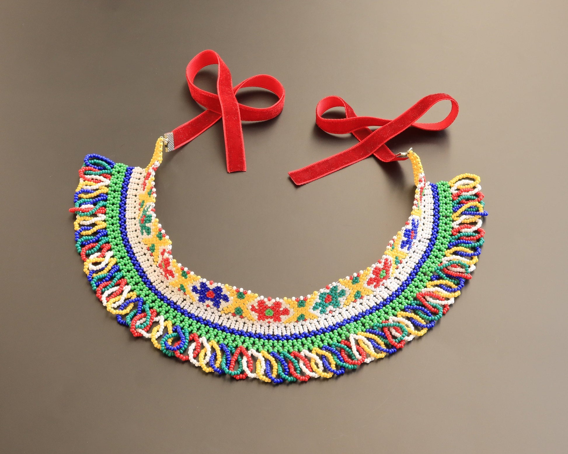 Comely UA traditional Ukrainian beaded silyanka necklace with floral motifs in yellow, green, red, blue, and white. Features red velvet ribbons.