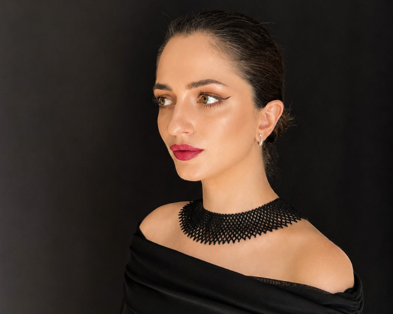 Comely UA black beaded silyanka necklace, a flat woven choker with a rhythmic pattern, worn by a model.