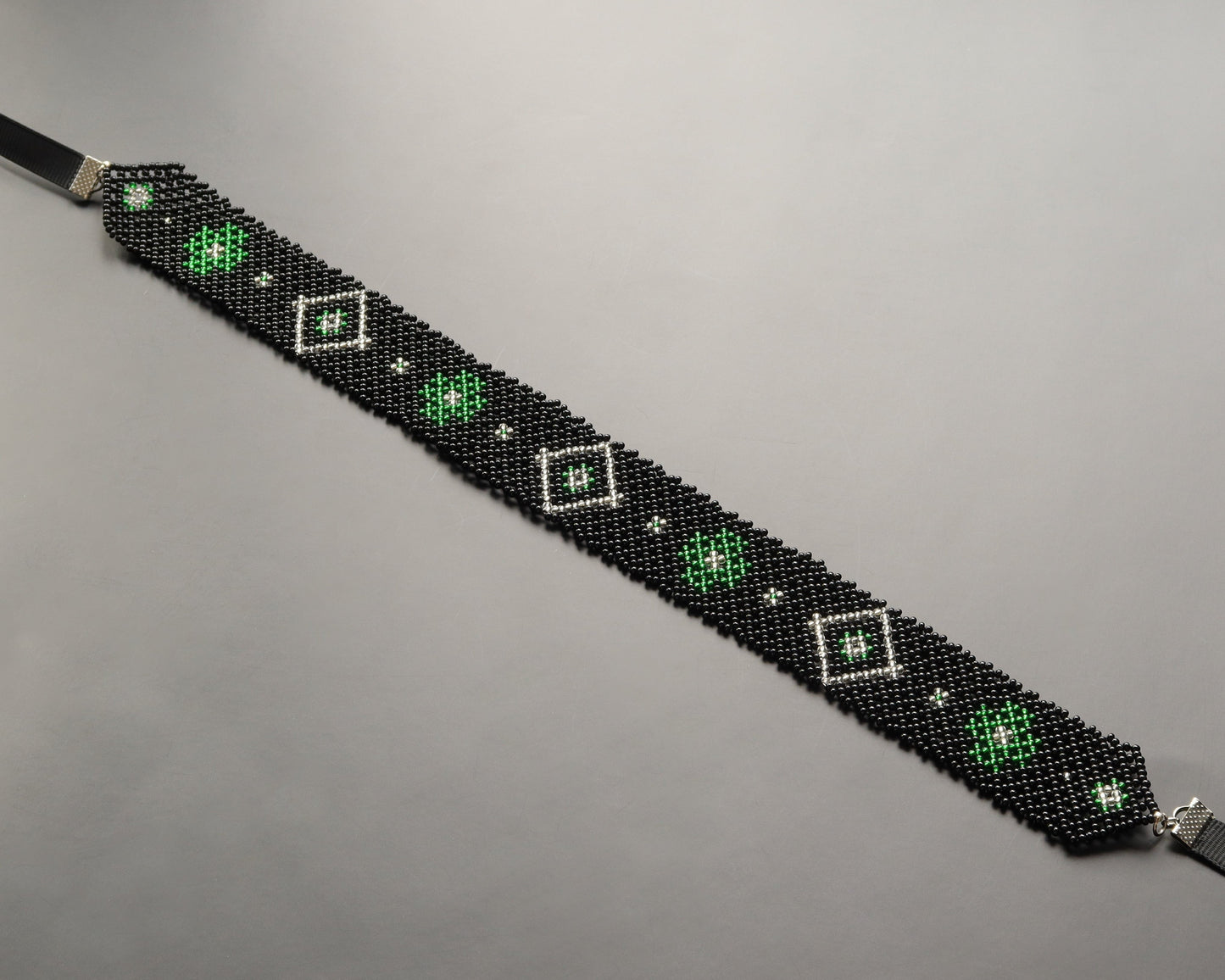 Comely UA black beaded gerdan with green and white diamond pattern. Czech seed beads, nylon thread, satin ribbons.