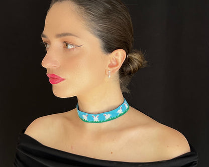 Comely UA blue beaded gerdan necklace with white hares and green grass pattern. Adjustable ties with tassels.