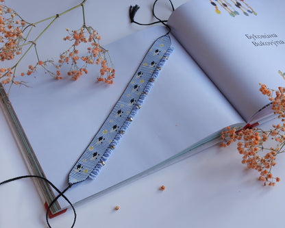 Comely UA light blue beaded gerdan with white daisies and sheep pattern, featuring silver bead fringe and black tassels.