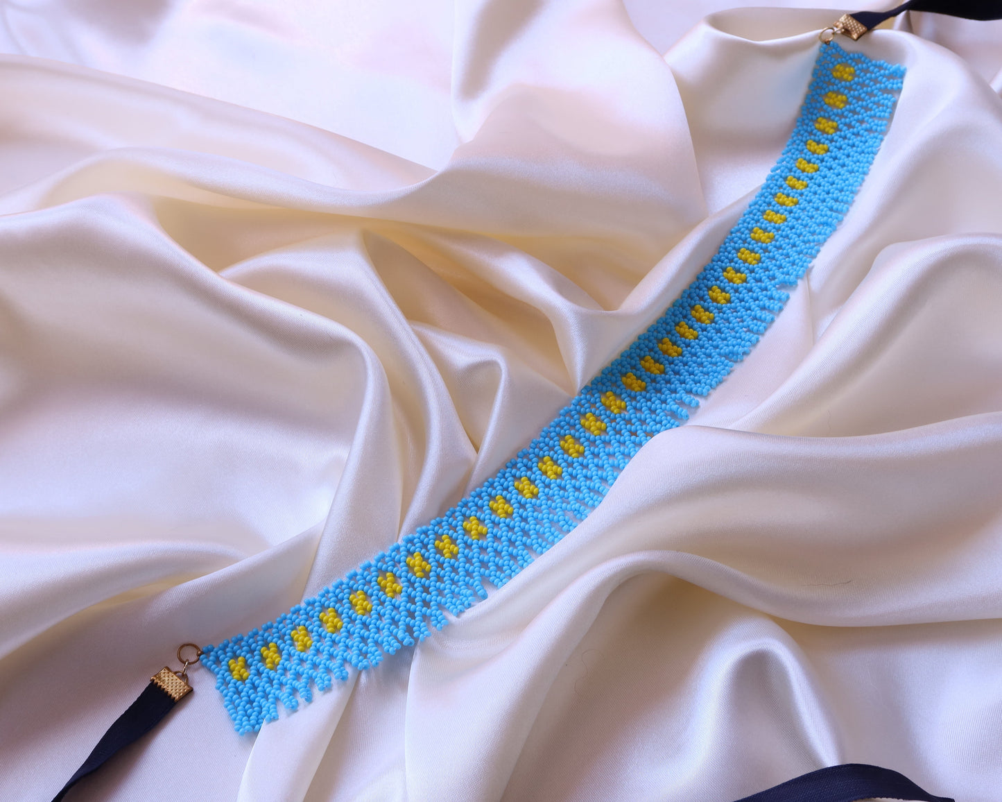 Comely UA blue and yellow beaded gerdan necklace, inspired by Pokuttian traditions. Features rhythmic yellow seed bead pattern on a blue background.