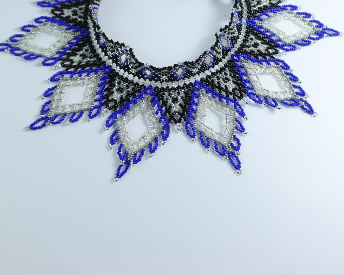 Comely UA Evian beaded necklace with blue, black, and silver diamond patterns. Czech seed beads, nylon thread, velvet ribbon ties.