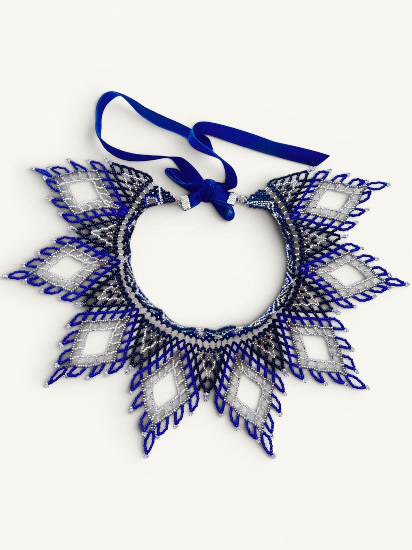 Comely UA Evian beaded necklace with diamond pattern in blue, silver, and black Czech seed beads. Features velvet ribbon ties.