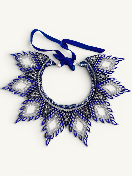 Comely UA Evian beaded necklace with diamond pattern in blue, silver, and black Czech seed beads. Features velvet ribbon ties.