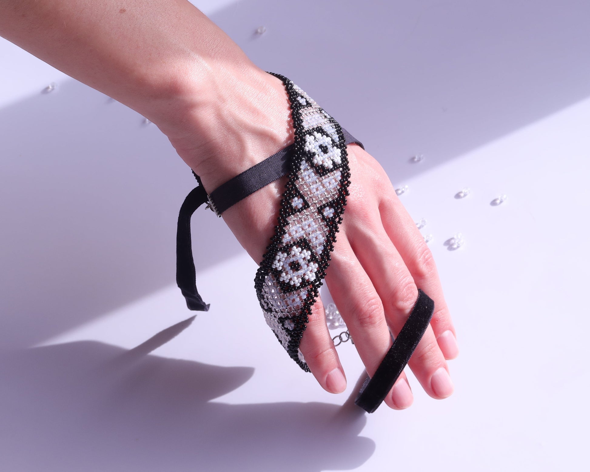 Comely UA beaded gerdan bracelet with black, milk, and clear glass beads in a traditional Hutsul geometric pattern.