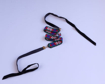 Comely UA Gerdan necklace with red, blue, green, and white diamond beadwork and black velvet ties.