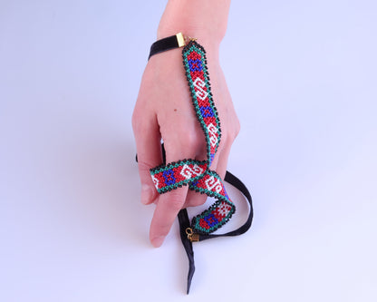 Comely UA Gerdan necklace with red, blue, white, and green geometric beadwork on black velvet ties. Circa 1920s Transcarpathian design.