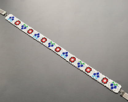 Comely UA white beaded gerdan necklace with red, blue, and green floral motifs. Adjustable velvet ribbon closure.
