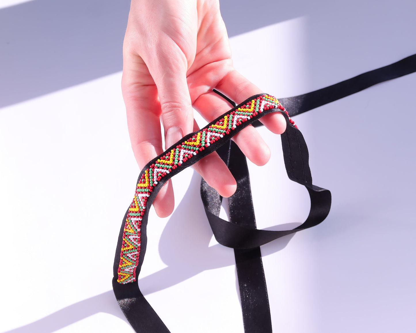 Comely UA Gerdan "Three Fires" beaded ribbon with red, yellow, green, and white geometric diamond pattern on black satin.