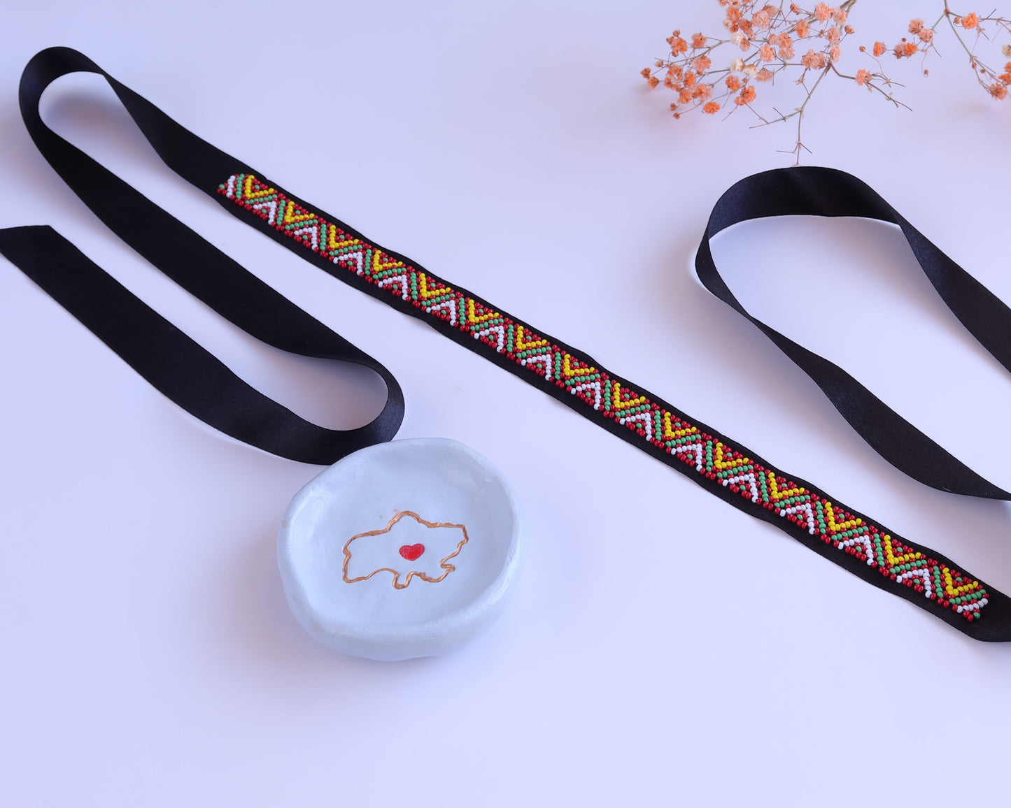 Comely UA Gerdan "Three Fires" beaded ribbon necklace with geometric diamond motif in red, yellow, and green on black satin.