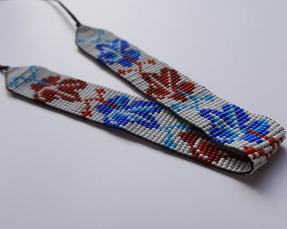Comely UA beaded gerdan necklace with red and blue leaf pattern on white background. Czech seed beads.