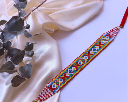 Comely UA Khust Ornament beaded gerdan with red, yellow, blue, and white geometric diamond pattern. Adjustable clasp.