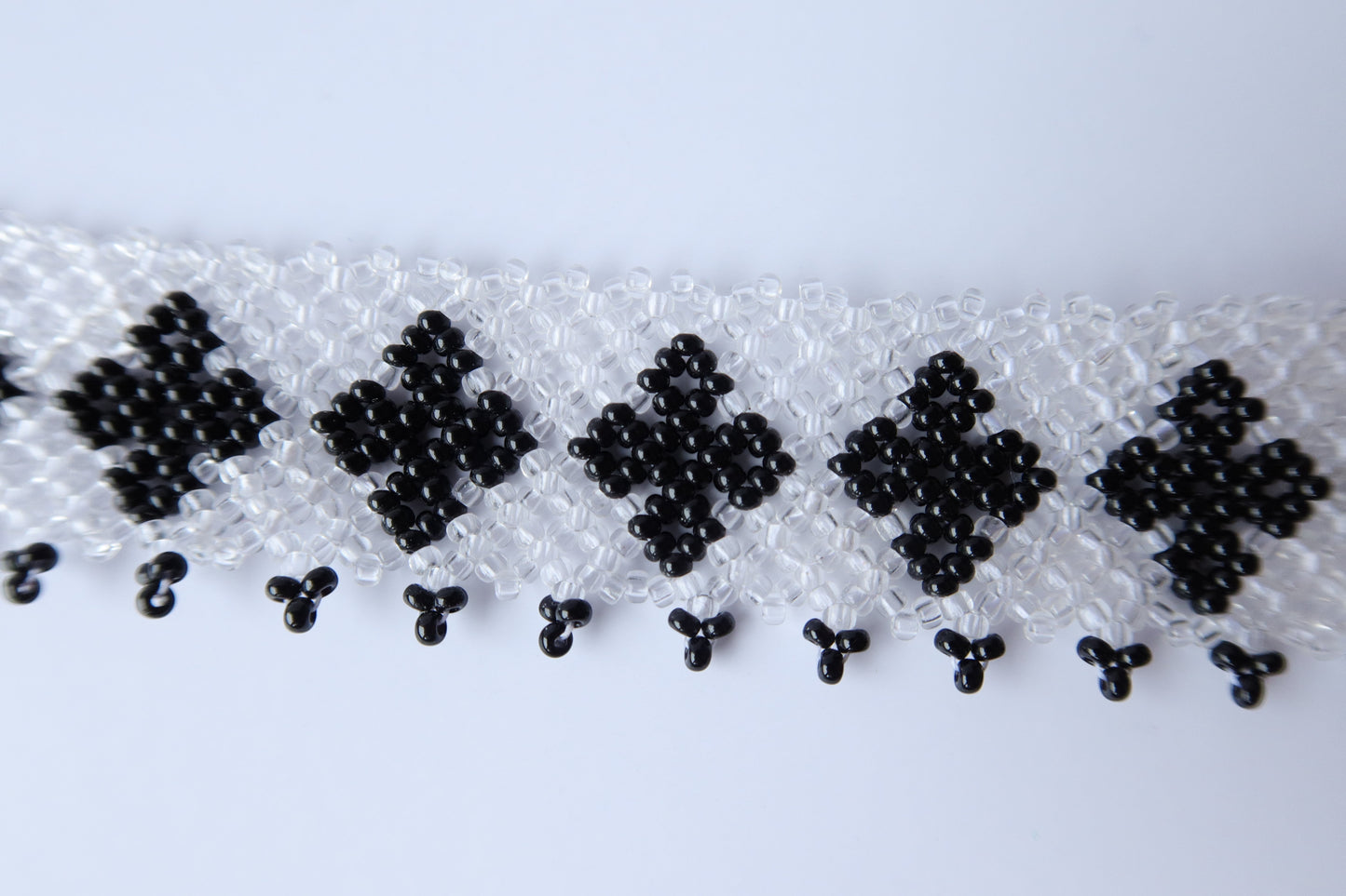 Comely UA "Ladana" gerdan necklace with black diamond patterns on a transparent beaded base and fringed edge.