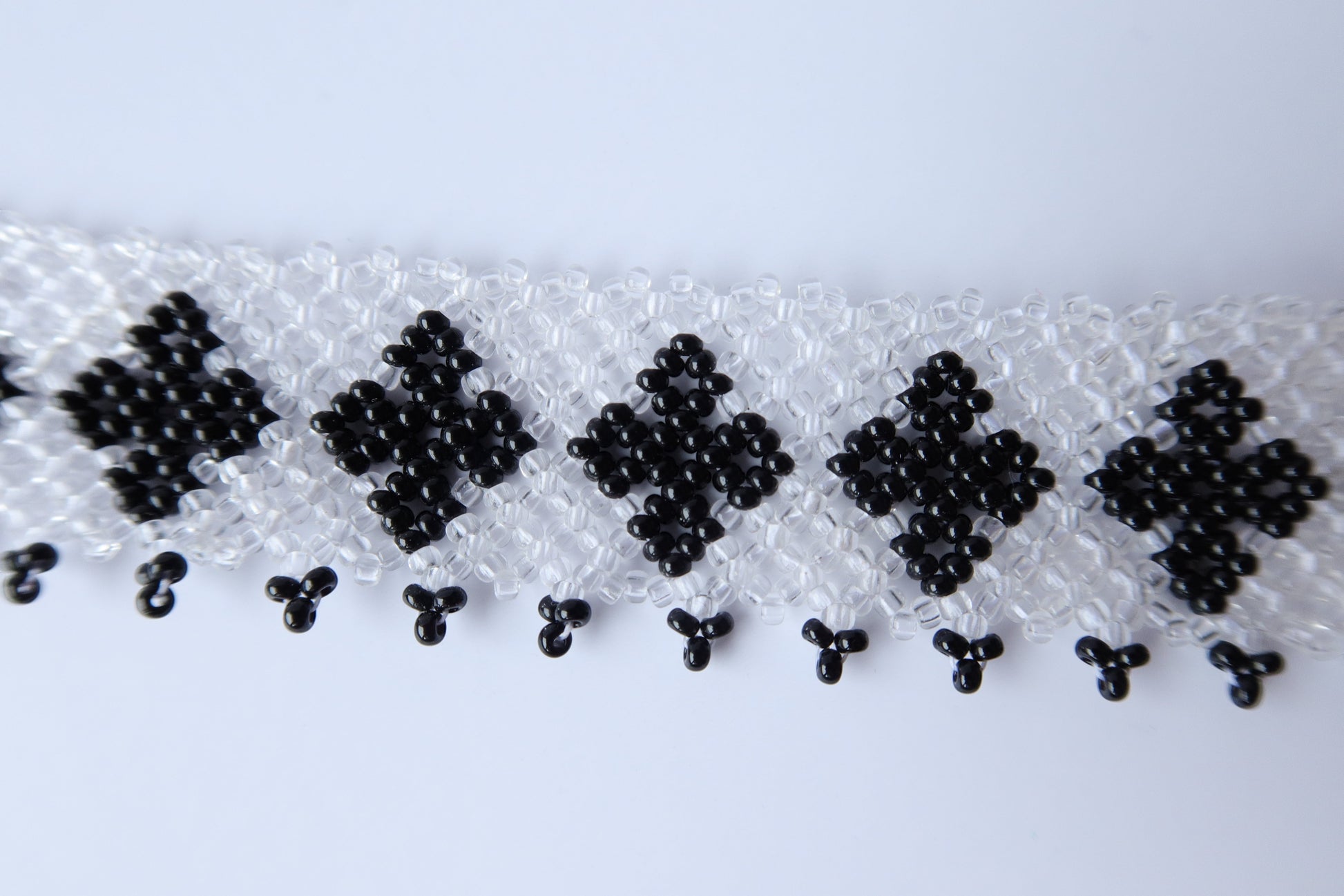Comely UA "Ladana" gerdan necklace with black diamond patterns on a transparent beaded base and fringed edge.