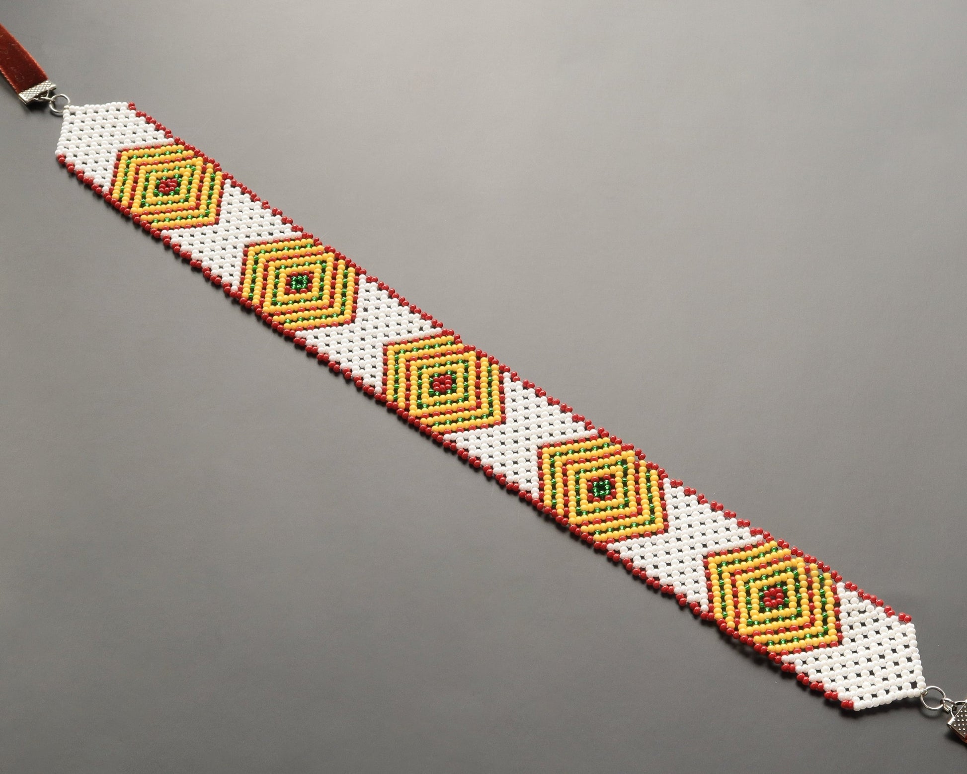 Comely UA white beaded gerdan with diamond pattern in yellow, green, and red. Features velvet ribbons for adjustable fit.