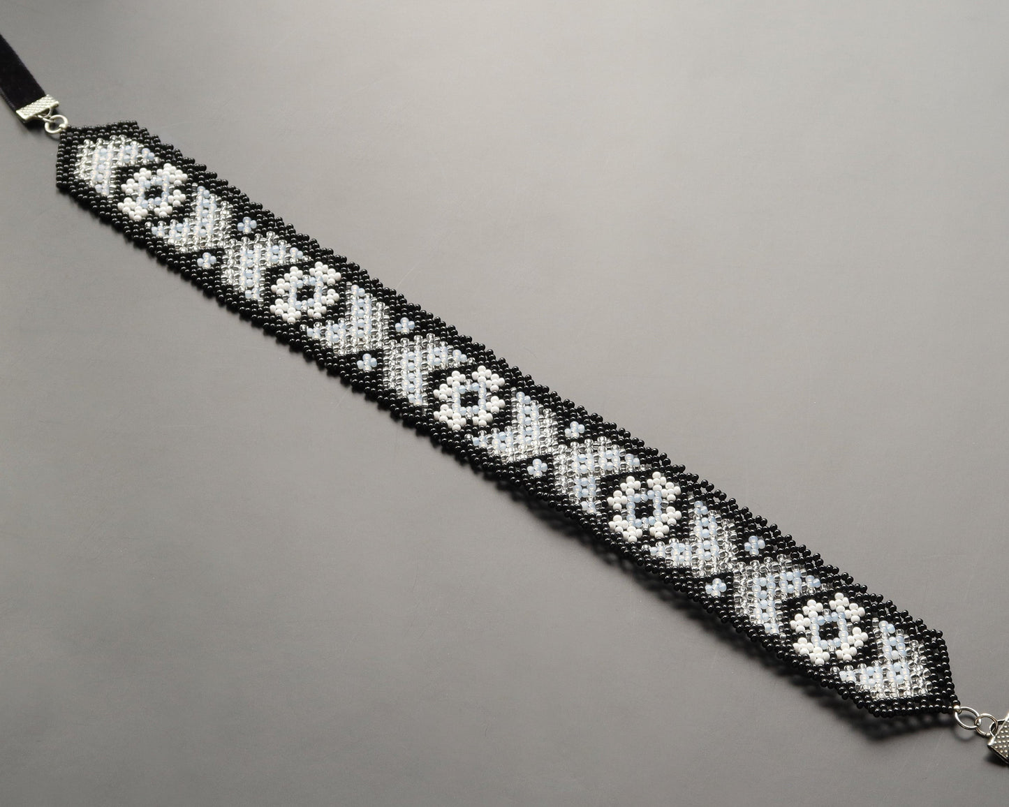 Comely UA Mistweaver gerdan necklace with black, milk, and clear Czech seed beads in a geometric pattern. Adjustable velvet ribbons.