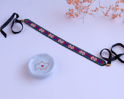 Comely UA Neresnytsia gerdan choker with red, blue, green, and white diamond beadwork and black velvet ties.