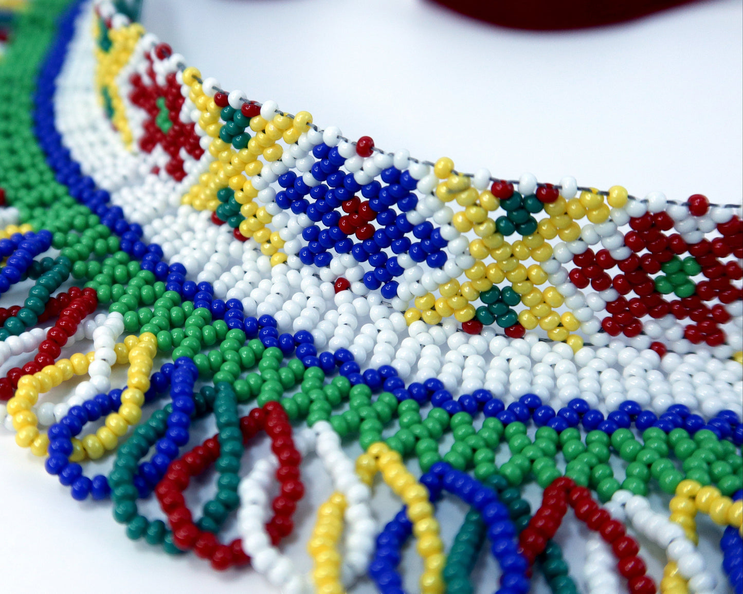 Comely UA Silyanka beaded necklace with floral and sun motifs in red, yellow, blue, green, and white Czech seed beads.