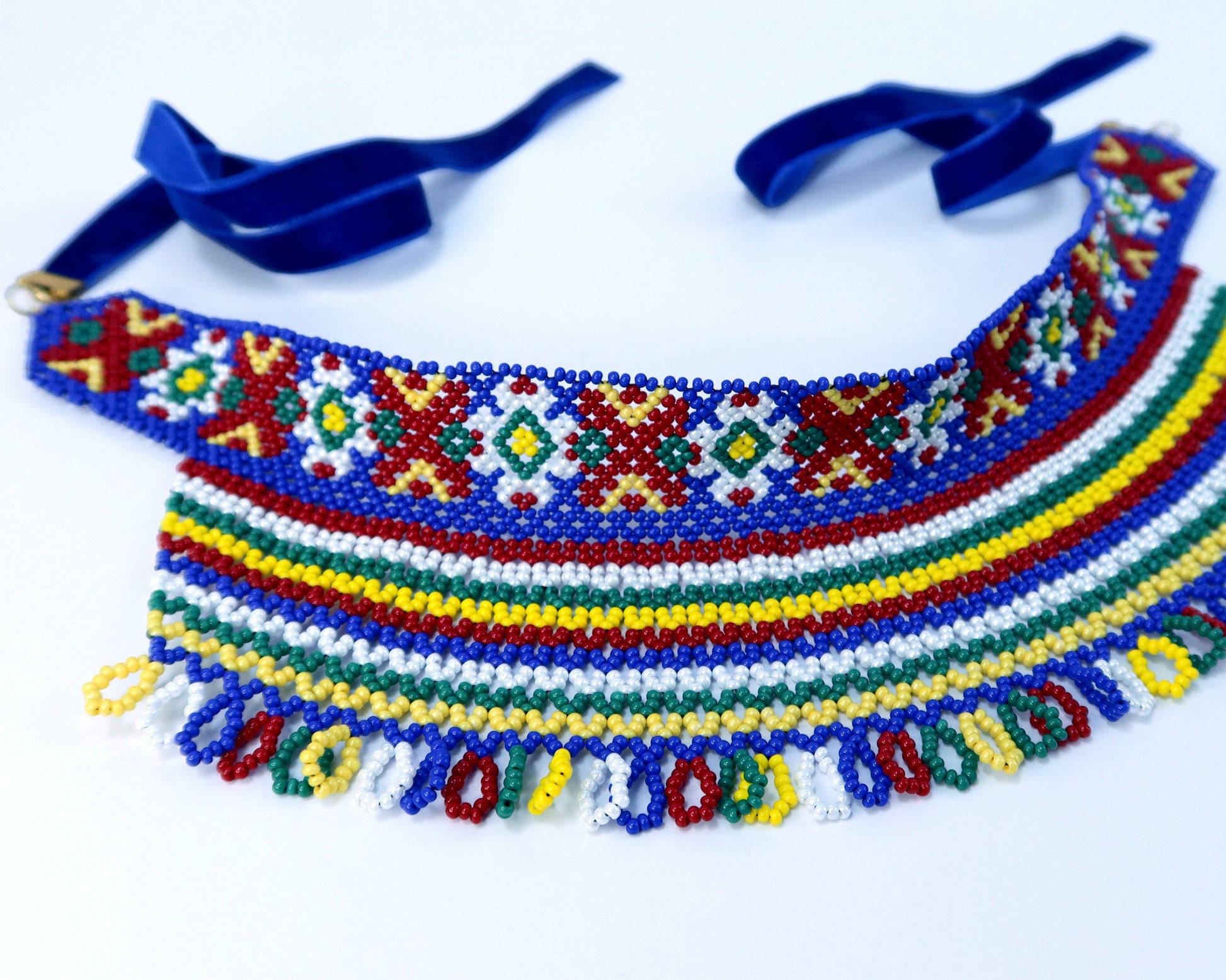 Comely UA two-part silyanka necklace with traditional Ukrainian beadwork in red, yellow, green, blue, and white. Features floral and solar motifs with beaded fringe and blue velvet ribbons.
